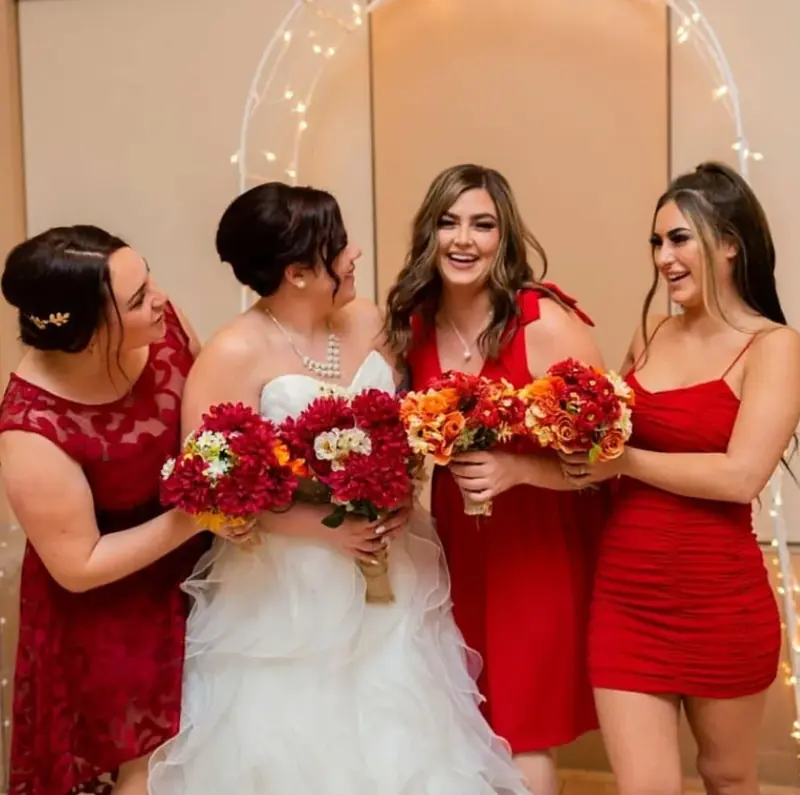 Bride and bridesmaids in red with their bouquets
