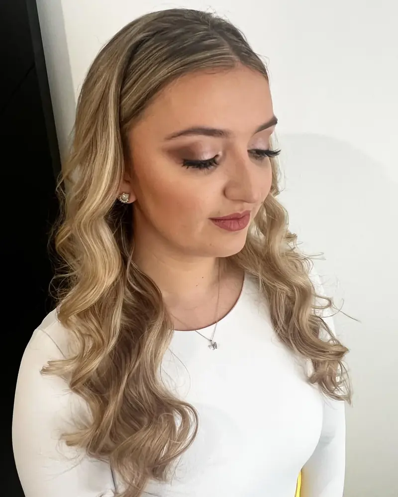 Soft glam makeup with long blonde waves